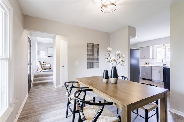 dining area with light wood-type flooring and baseboards