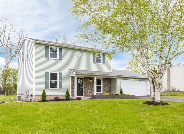 traditional-style home with asphalt driveway, a garage, and central AC unit