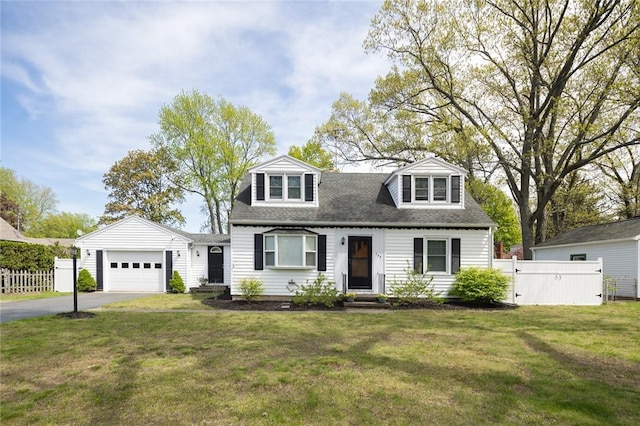 new england style home featuring driveway, a garage, and roof with shingles
