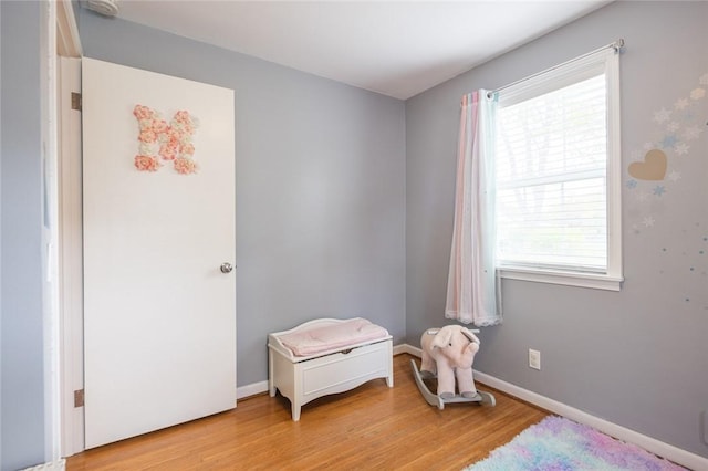 bedroom featuring wood finished floors, multiple windows, and baseboards