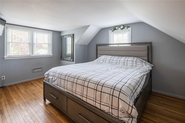bedroom with wood finished floors, baseboards, and lofted ceiling