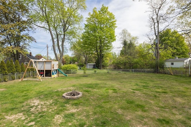 view of yard with a playground and a fire pit