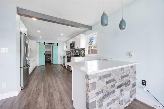1019 State Route 49, Constantia, NY 13028 - kitchen featuring stainless steel appliances, a barn door, washer / dryer, dark wood-type flooring, and white cabinetry
