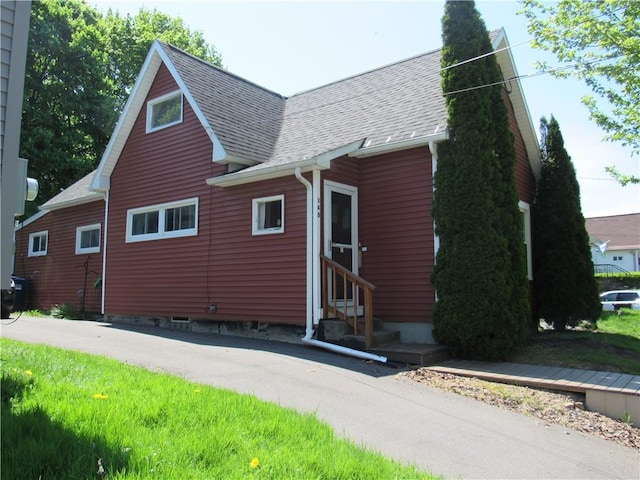view of front of home with entry steps and a shingled roof