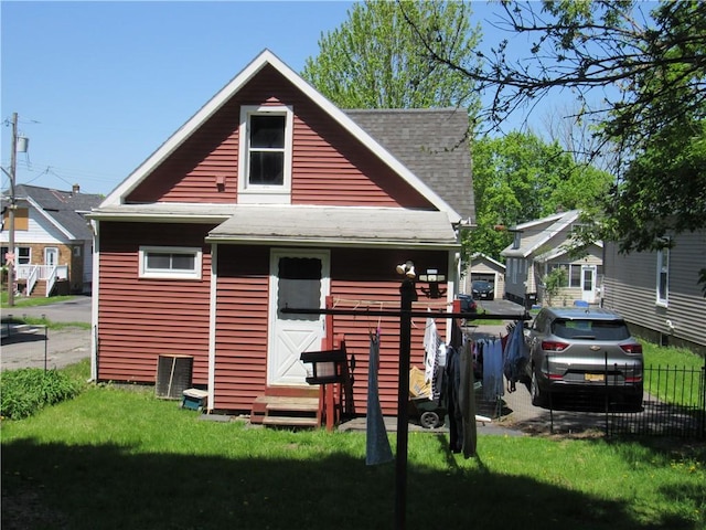 rear view of house featuring roof with shingles and entry steps