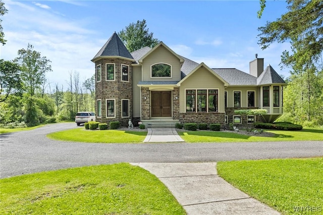 3750 Transit Rd, Orchard Park, NY 14127 - view of front of home featuring a chimney, a front yard, and stone siding