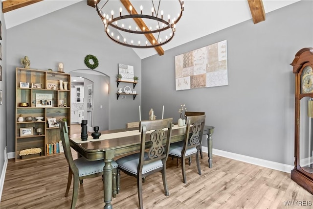 3750 Transit Rd, Orchard Park, NY 14127 - dining area with beam ceiling, a chandelier, wood finished floors, arched walkways, and high vaulted ceiling