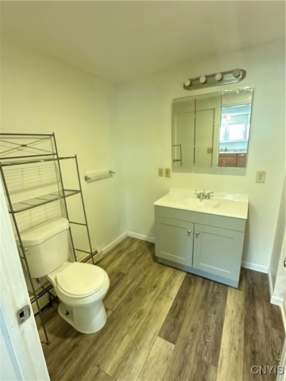 24 W Main St, Eaton, NY 13408 - bathroom with wood finished floors, toilet, baseboards, and vanity