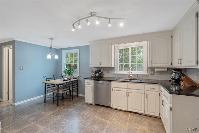 kitchen featuring stainless steel dishwasher, a sink, dark countertops, backsplash, and healthy amount of natural light