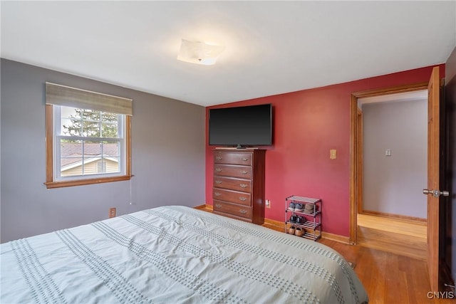bedroom with wood finished floors and baseboards