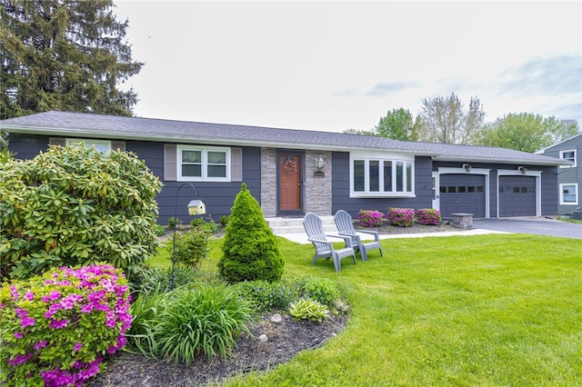 view of front of home with an attached garage, a front yard, and asphalt driveway