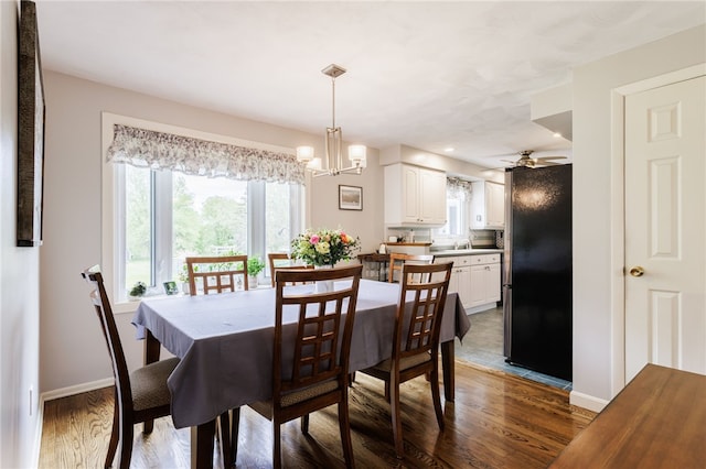 dining area featuring dark wood-type flooring, baseboards, ceiling fan, and a chandelier