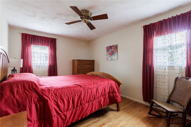 bedroom with wood finished floors, baseboards, and ceiling fan