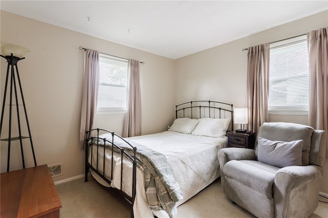 bedroom featuring light carpet and baseboards