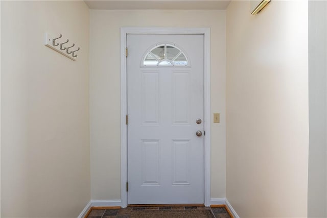 doorway to outside featuring baseboards