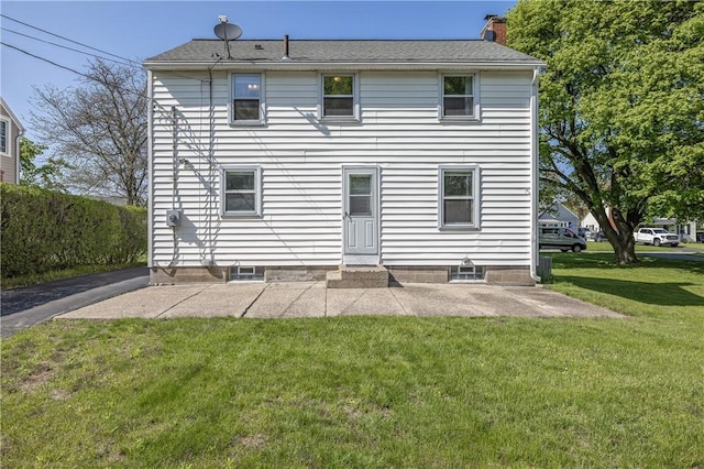 back of property featuring a yard, a patio, and a chimney