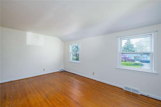 bonus room with lofted ceiling, baseboards, and wood finished floors