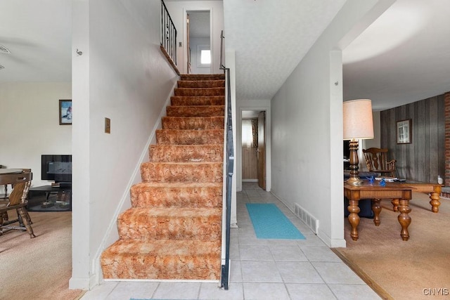 staircase featuring tile patterned flooring