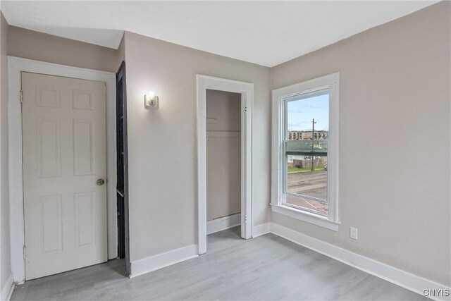 121 Roney Rd, Syracuse, NY 13205 - unfurnished bedroom with light wood-style flooring, baseboards, and a closet