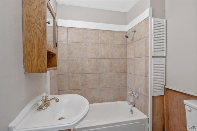 121 Roney Rd, Syracuse, NY 13205 - bathroom with a sink, radiator heating unit, shower / washtub combination, and toilet