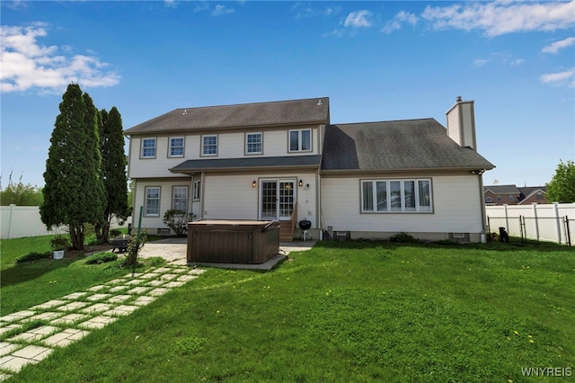 back of property featuring a hot tub, a chimney, and a patio