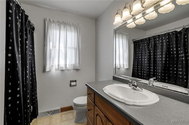 bathroom with toilet, baseboards, and vanity