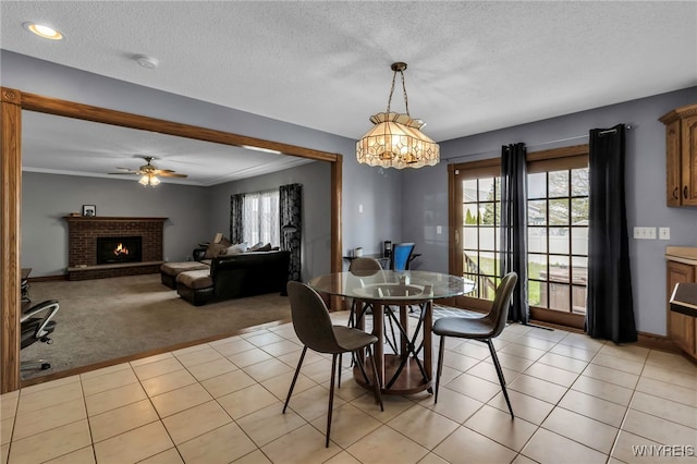 3472 Stevenson Ct, Wheatfield, NY 14120 - dining space with light carpet, a chandelier, a brick fireplace, a ceiling fan, and baseboards