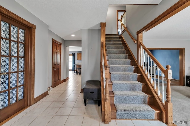 stairs with tile patterned floors, baseboards, and recessed lighting