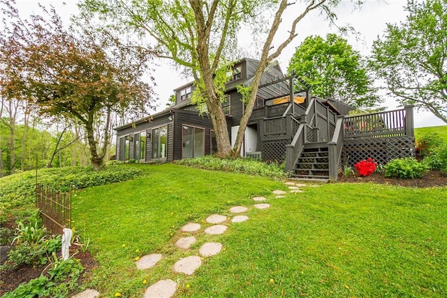 view of green lawn featuring a deck and stairs