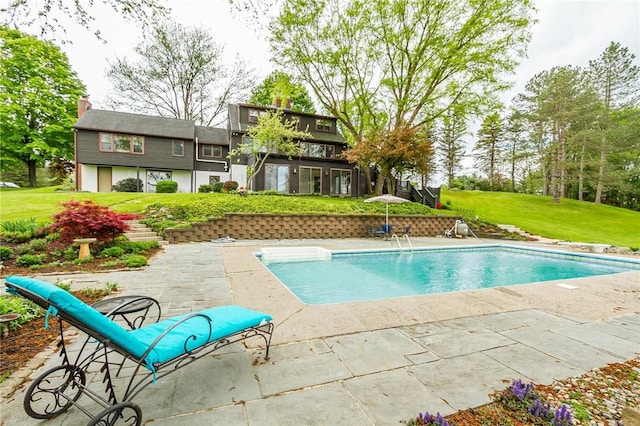 outdoor pool with a yard and a patio