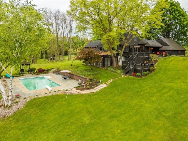 view of green lawn featuring stairs, an outdoor pool, a patio area, and a wooden deck