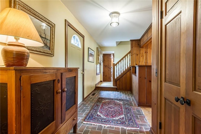 entryway with brick flooring and stairs