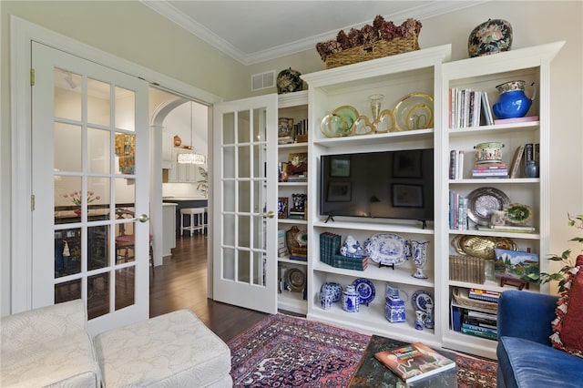living room featuring french doors, ornamental molding, arched walkways, and wood finished floors