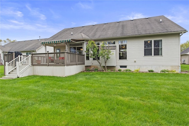 back of property featuring a wooden deck, a yard, and roof with shingles