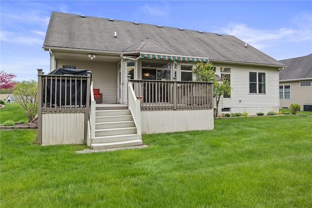 rear view of property with a lawn, roof with shingles, and central AC unit
