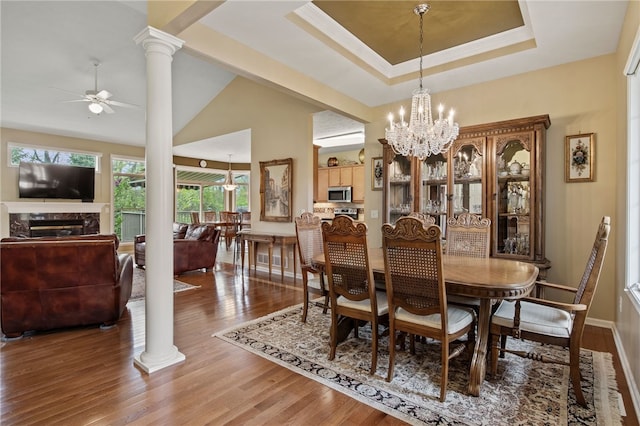 dining room with ornate columns, a ceiling fan, wood finished floors, and a chandelier