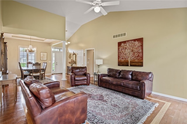 living area featuring a chandelier, wood finished floors, ceiling fan, lofted ceiling, and baseboards