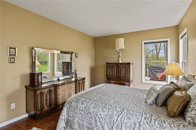 bedroom with dark wood-style flooring and baseboards