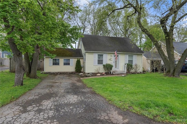 cape cod-style house featuring a front yard and driveway