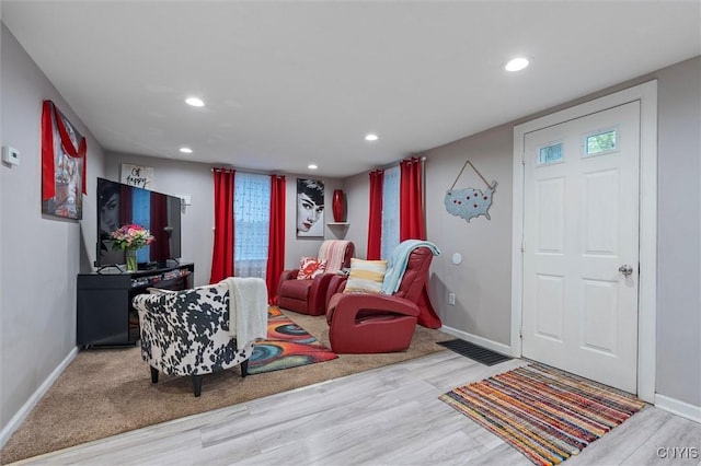 living area with wood finished floors, baseboards, and recessed lighting