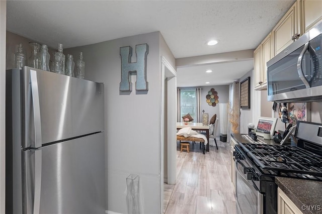 kitchen featuring stainless steel appliances, cream cabinets, light wood-style flooring, and recessed lighting