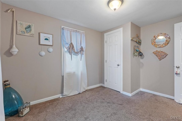 interior space featuring carpet and baseboards