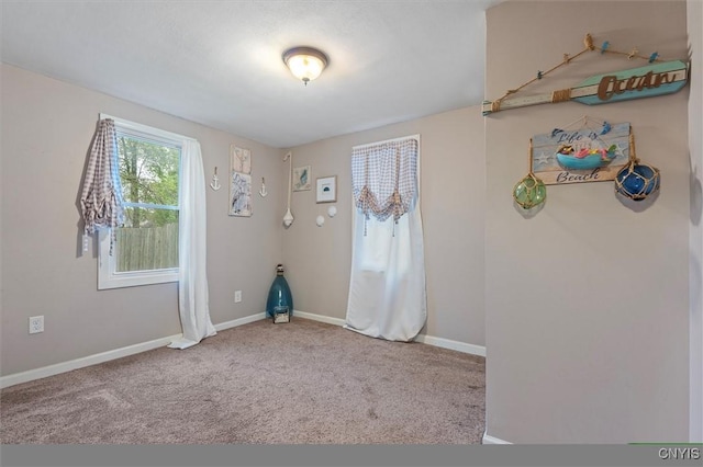 unfurnished room with baseboards and carpet flooring