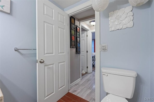 bathroom featuring wood finished floors, toilet, and baseboards