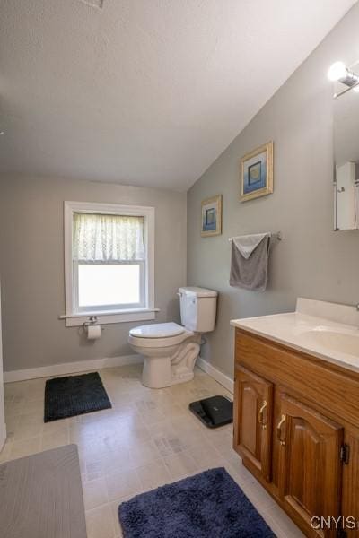 7735 Coates Rd N, Trenton, NY 13354 - bathroom with baseboards, lofted ceiling, vanity, and toilet