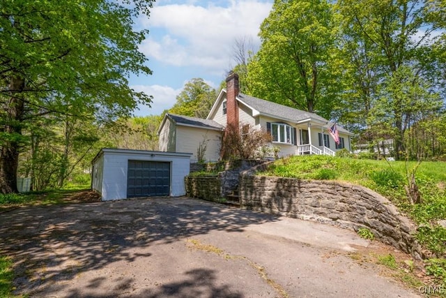 7735 Coates Rd N, Trenton, NY 13354 - view of property exterior with driveway, a garage, an outbuilding, and a chimney