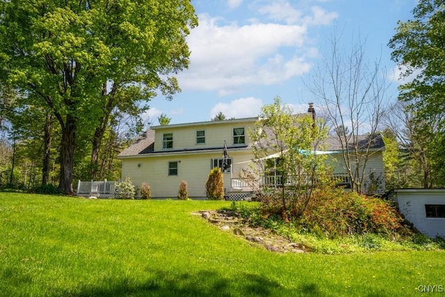 7735 Coates Rd N, Trenton, NY 13354 - rear view of property featuring a lawn, a deck, and a chimney