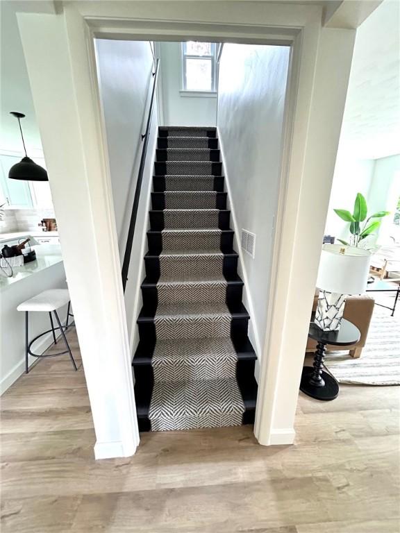 stairway featuring wood finished floors and baseboards