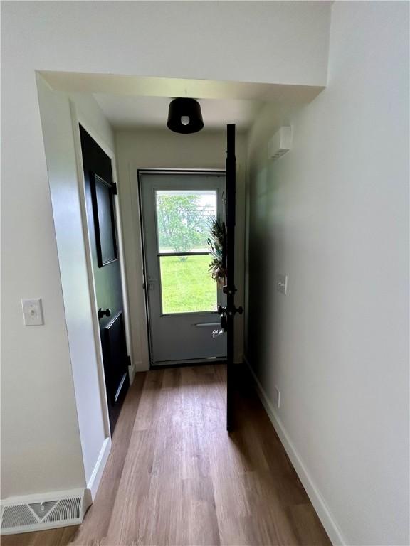 doorway featuring wood finished floors and baseboards