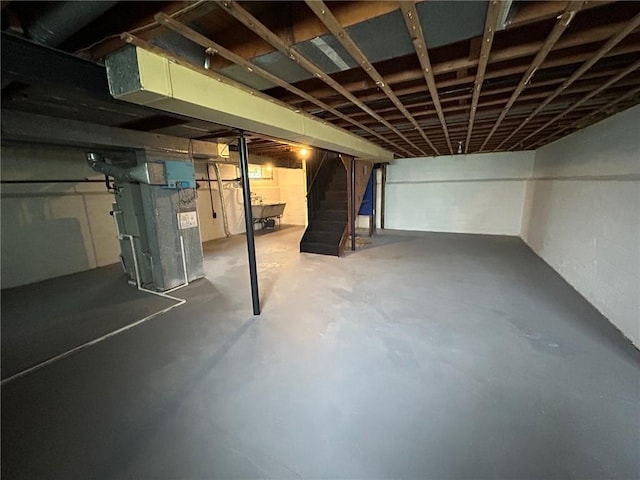 unfinished below grade area featuring stairway and heating unit